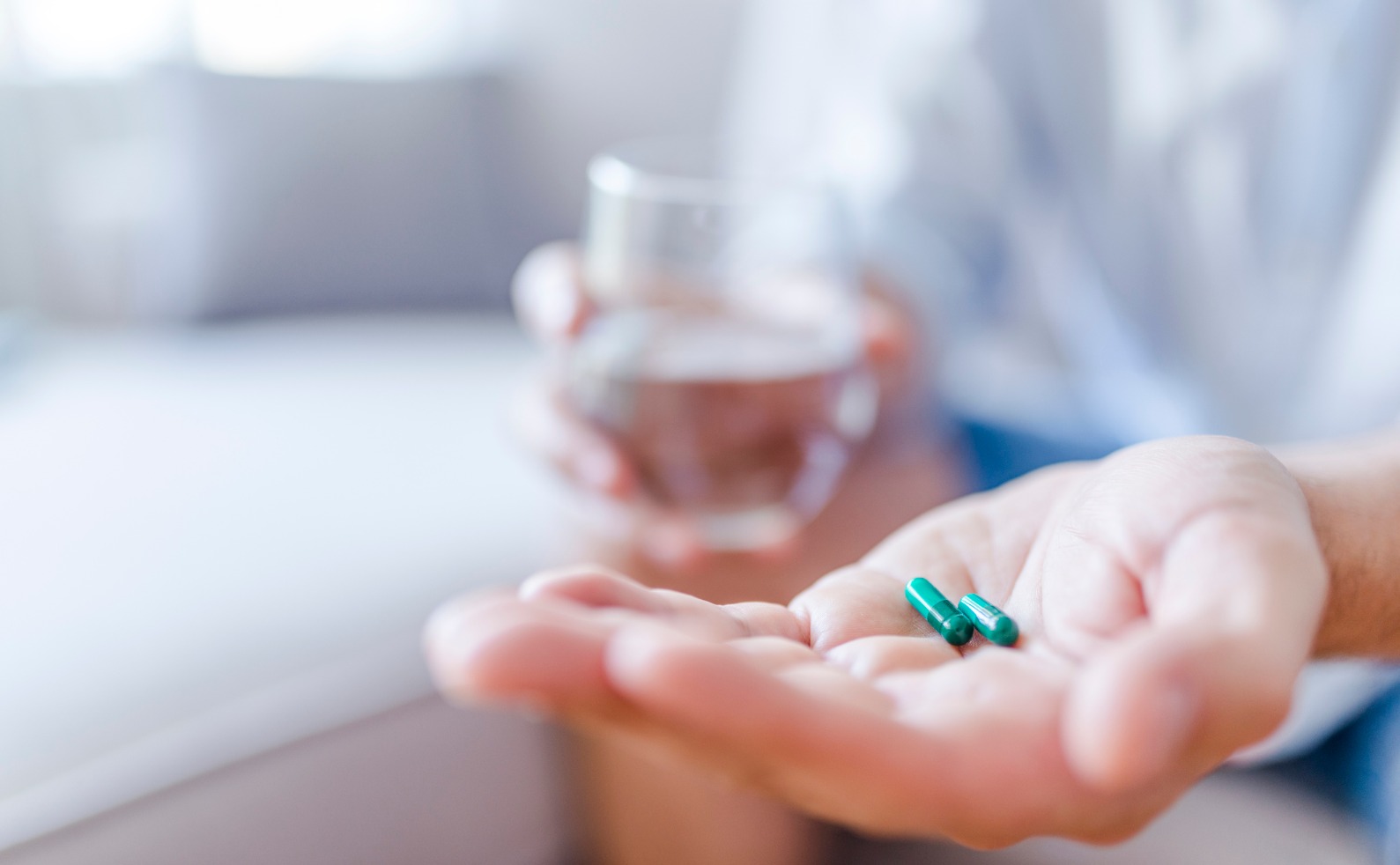 man takes medicines with glass of water picture id974152656