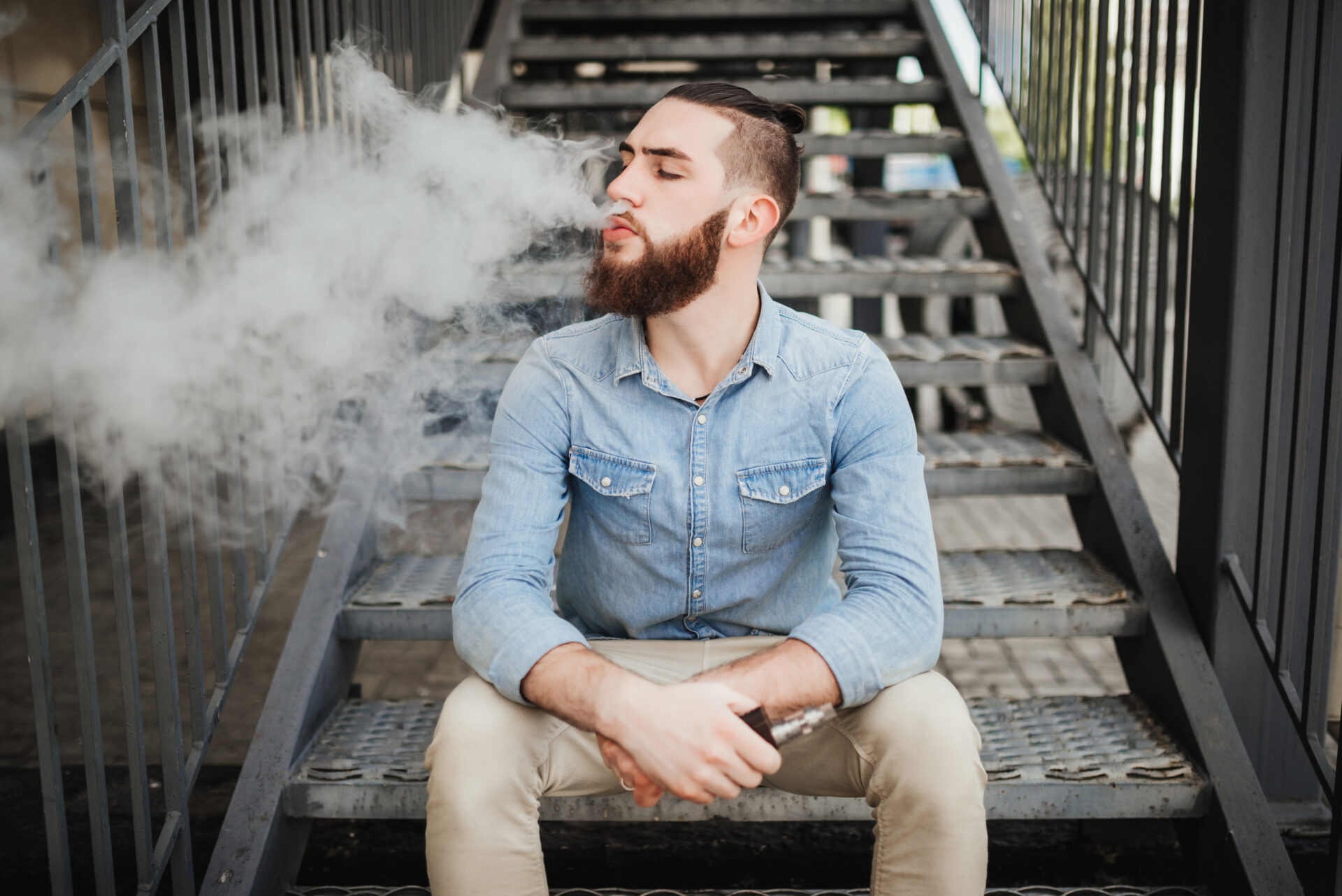 Vaping. Casual men with beard vaping an electronic cigarette.