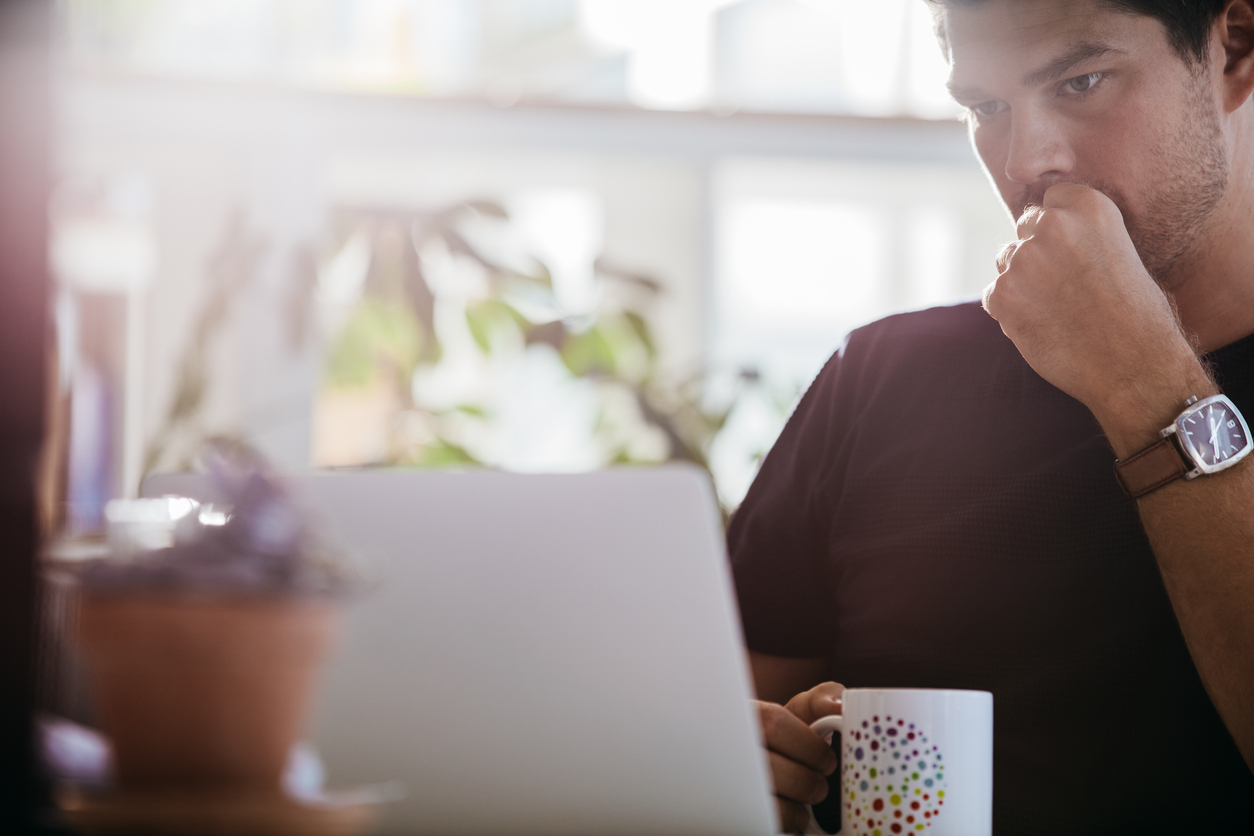 Serious male executive looking at laptop